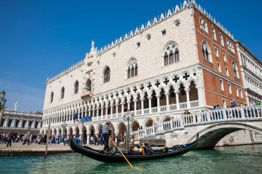 Venedik'teki Büyük Kanal'da Doge Sarayı'nın önünde bir gondolda yelken süren turistler