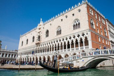 Venedik'teki Büyük Kanal'da Doge Sarayı'nın önünde bir gondolda yelken süren turistler