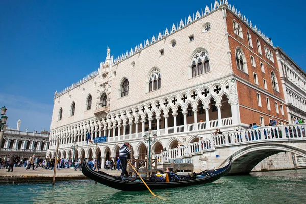 Venedik'teki Büyük Kanal'da Doge Sarayı'nın önünde bir gondolda yelken süren turistler