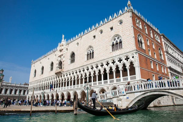 Venedik'teki Büyük Kanal'da Doge Sarayı'nın önünde bir gondolda yelken süren turistler