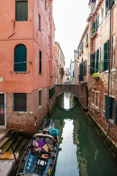 Gondolier alistando su góndola en un hermoso canal en Venecia — Foto de Stock