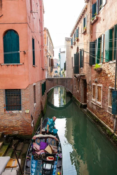 Gondolier alistando su góndola en un hermoso canal en Venecia — Foto de Stock