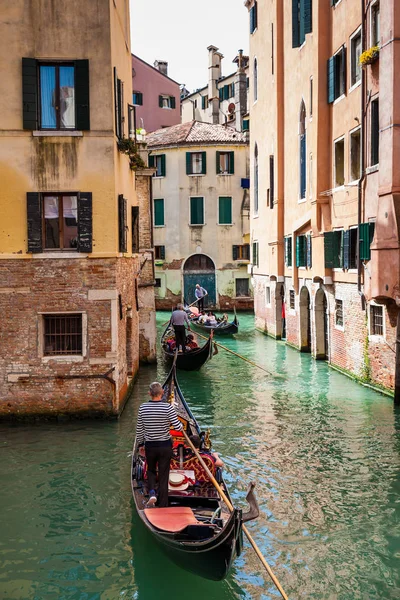 Turistas navegando en una góndola en los hermosos canales de Venecia en un día de primavera — Foto de Stock