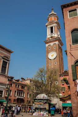 Turistler ve yerliler güneşli bir erken bahar gününde Venedik güzel sokaklarında yürüyüş