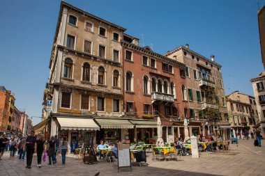 Turistler ve yerliler güneşli bir erken bahar gününde Venedik güzel sokaklarında yürüyüş