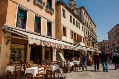 Turistler ve yerliler güneşli bir erken bahar gününde Venedik güzel sokaklarında yürüyüş