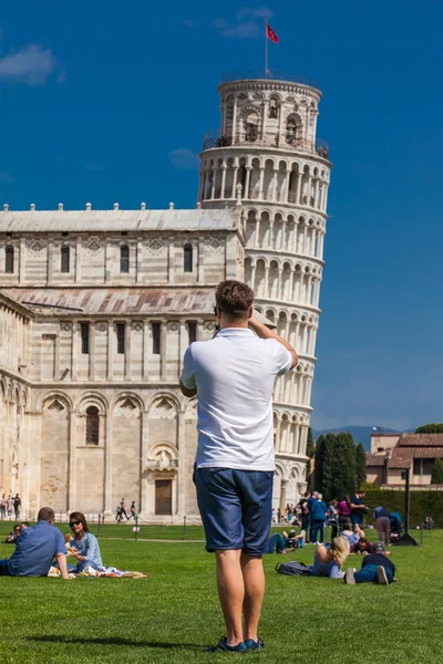 Mladý muž, který fotografoval slavnou šikmou věž v Pise — Stock fotografie