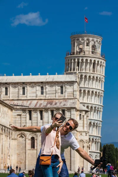 年轻的一对游客在著名的比萨斜塔前自拍 — 图库照片