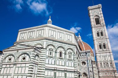 The Giotto Campanile and Florence Cathedral consecrated in 1436 against a beautiful blue sky clipart