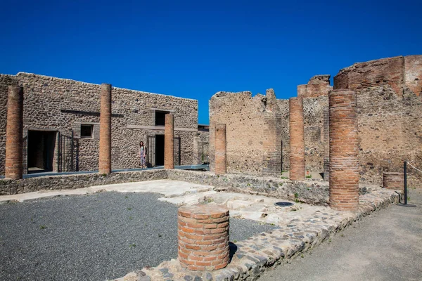 Meisje een bezoek aan de ruïnes van de huizen in de oude stad van Pompeii in een prachtige vroege lente dag — Stockfoto