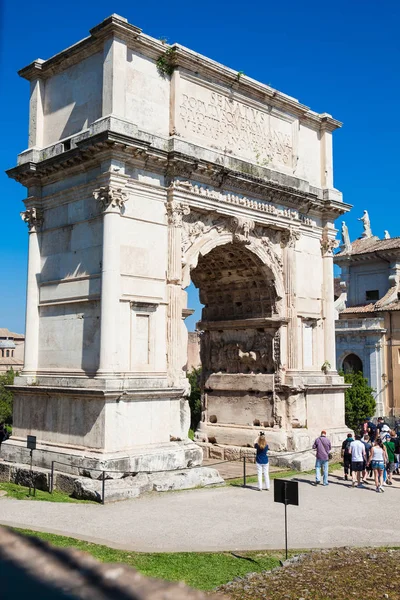 Touristen am Konstantinbogen, einem Triumphbogen in Rom, gelegen zwischen dem Kolosseum und dem Palatin, der im Jahr 315 erbaut wurde. ad — Stockfoto