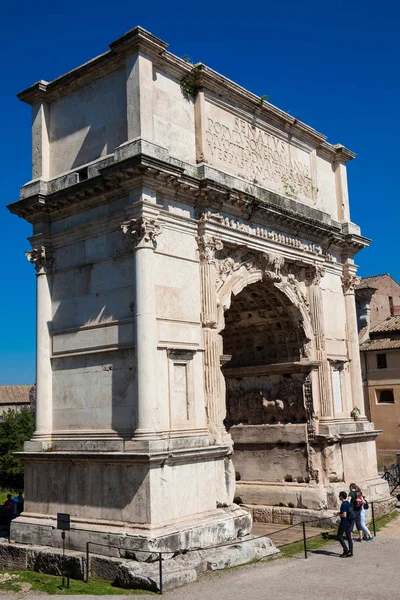 Touristen am Konstantinbogen, einem Triumphbogen in Rom, gelegen zwischen dem Kolosseum und dem Palatin, der im Jahr 315 erbaut wurde. ad — Stockfoto