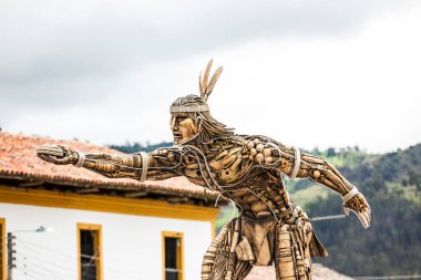 Monument to Chaquen the god of sports and fertility in the religion of the Muiscas indigenous playing the national Colombian game called tejo clipart