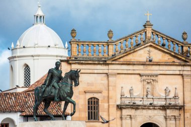 Equestrian monument to the Liberator Simon Bolivar with the Basilica of St. James the Apostle on background at the Bolivar Square in the Colombian city of Tunja clipart