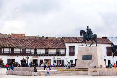 Tourists and locals at the beautiful Bolivar Square in Tunja city clipart