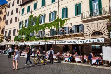 Piazza Navona'daki restoranlarda güzel bir bahar günü keyfi turistler