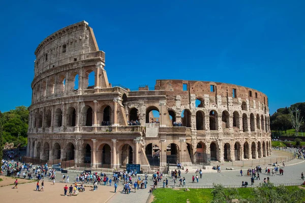 Turister som besöker den berömda Colosseum i Rom i en vacker tidig vårdag — Stockfoto