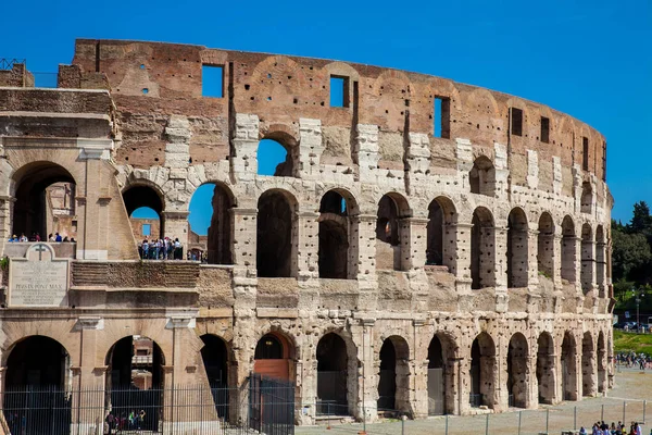 Turister som besöker den berömda Colosseum i Rom i en vacker tidig vårdag — Stockfoto