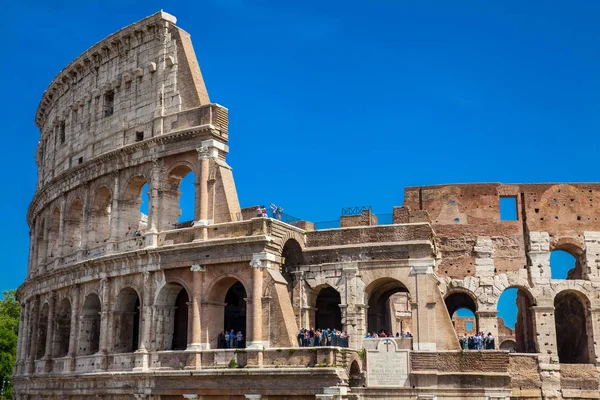 Turister som besöker den berömda Colosseum i Rom i en vacker tidig vårdag — Stockfoto