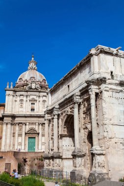 Roma'daki Roma Forumu'nda Santi Luca e Martina Kilisesi ve Septimius Severus Kemeri'ni ziyaret eden turistler