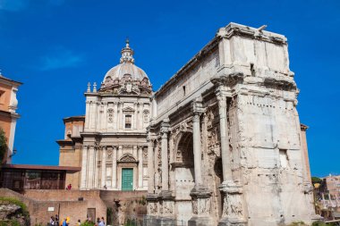 Roma'daki Roma Forumu'nda Santi Luca e Martina Kilisesi ve Septimius Severus Kemeri'ni ziyaret eden turistler