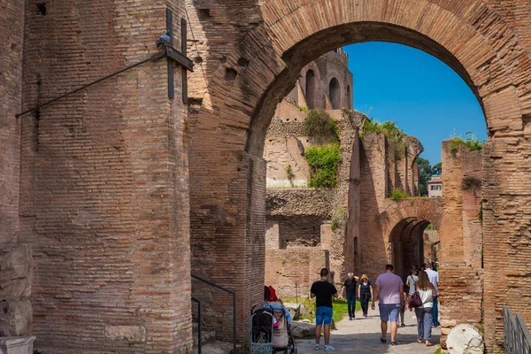 로마의 고대 로마 포럼에 비아 노바에서 아치로 걷는 관광객 — 스톡 사진
