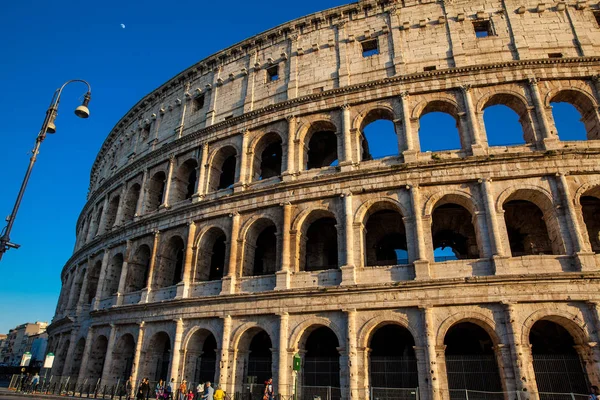 Turister som besöker den berömda Colosseum under det vackra ljuset av den gyllene timmen i Rom — Stockfoto
