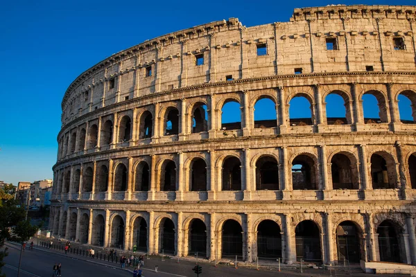 Turisti che visitano il famoso Colosseo sotto la bella luce dell'ora d'oro di Roma — Foto Stock