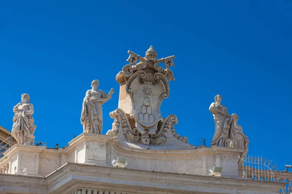 Detalle de los escudos de armas Chigi y las estatuas de santos que coronan las columnatas de la Plaza de San Pedro construidas en 1667 en la Ciudad del Vaticano — Foto de Stock