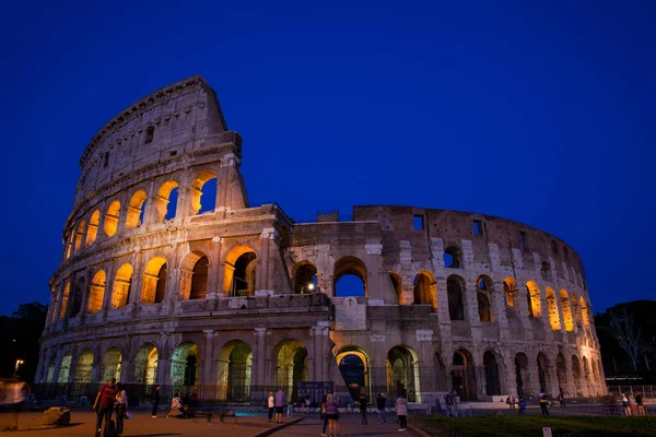 Turistas visitando el famoso Coliseo por la noche en Roma — Foto de Stock