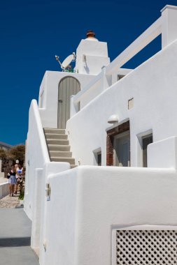 Turistler güzel bir erken bahar gününde Santorini Adası'nda Fira City güzel sokaklarında yürüyüş