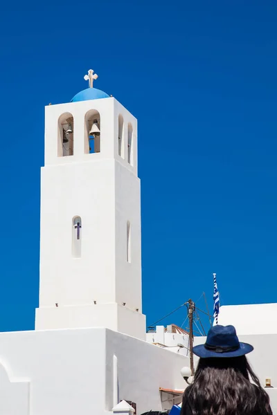 산토리니 피라에 위치한 성 게라시모스 교구 교회의 종탑을 바라보는 소녀 — 스톡 사진