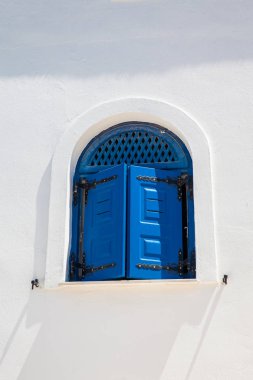 Santorini Adası'nda beyaz duvarlar üzerinde geleneksel güzel mavi pencereler