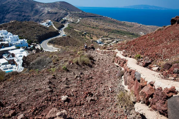 Pareja de turistas caminando por el sendero número 9 entre las ciudades de Fira y Oia en la isla de Santorini —  Fotos de Stock