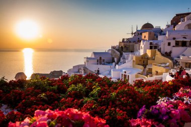 Turistler Santorini Adası'nda Oia şehirde La Caldera inanılmaz güzel gün batımı bakıyor