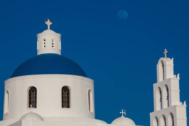 Güzel bir erken bahar gününde Santorini Adası'nda Oia şehrinde bulunan Panagia Platsani Kilisesi ve ay Kubbe ve çan kulesi