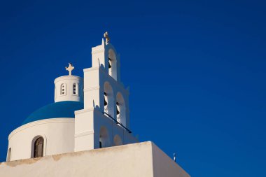 Güzel bir erken bahar gününde Santorini Adası'nda Oia şehirde bulunan Panagia Platsani Kilisesi Kubbe ve çan kulesi