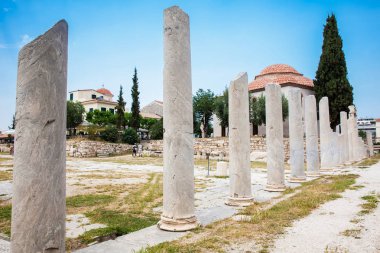 Atina 'daki Akropolis' in kuzeyinde yer alan Roma Agora 'daki antik harabeleri ziyaret eden turistler