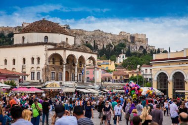 Büyük bir grup turist ve yerli Atina 'daki Monastiraki Meydanı' nda güzel bir bahar gününün tadını çıkarıyor