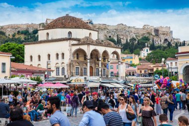 Büyük bir grup turist ve yerli Atina 'daki Monastiraki Meydanı' nda güzel bir bahar gününün tadını çıkarıyor