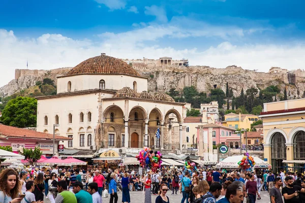 Büyük bir grup turist ve yerli Atina 'daki Monastiraki Meydanı' nda güzel bir bahar gününün tadını çıkarıyor