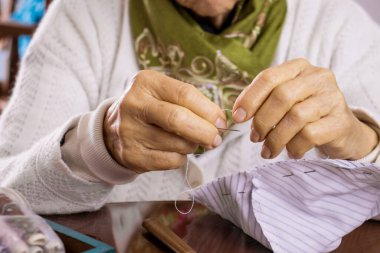 Son sınıf öğrencisi kadın Covid-19 salgını sırasında ev yapımı yüz maskesi dikiyor.