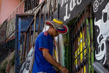 MEDELLİN, COLOMBIA - 17 HAZİRAN 2024 Medellin 'in ünlü Comuna 13' ünün sakini geleneksel Kolombiyalı Sombrero Vueltiao