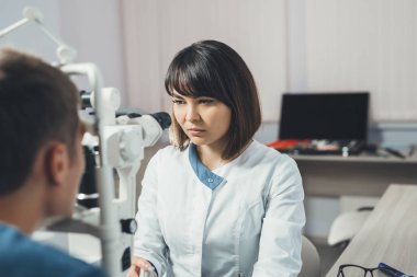 Doktor genç bir adamın vizyonu bakar. Hastane, klinik, tıbbi muayene.