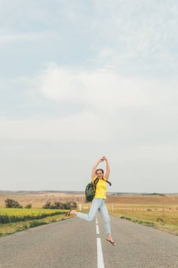 Genç kız yaz aylarında boş bir yolda atlar