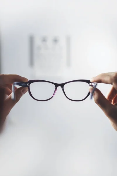 病人拿着眼镜看视力 在医院进行视力检查 专注于眼镜 — 图库照片