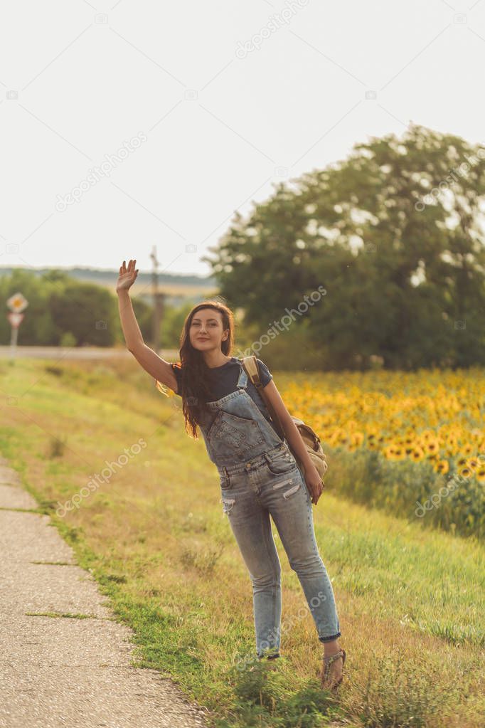 beautiful girl with  backpack hitchhiking. concept - travel, adventure, freedom. Copy space