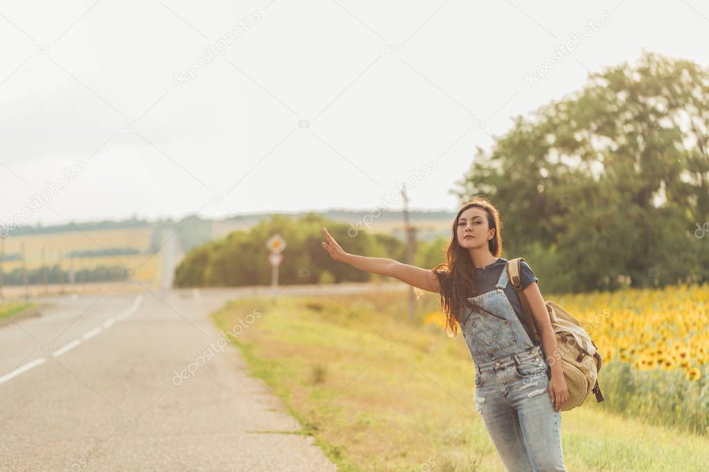 beautiful girl with  backpack hitchhiking. concept - travel, adventure, freedom. Copy space
