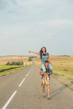 Otostop. Adam omuzlarında oturan kız. Çok iyi. Kavram - macera, özgür, özgürlük.