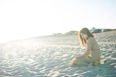 genç kız sahilde günbatımı hoşlanır. Güzel plaj, güneş ışınları. Metin için yer kopyalayın